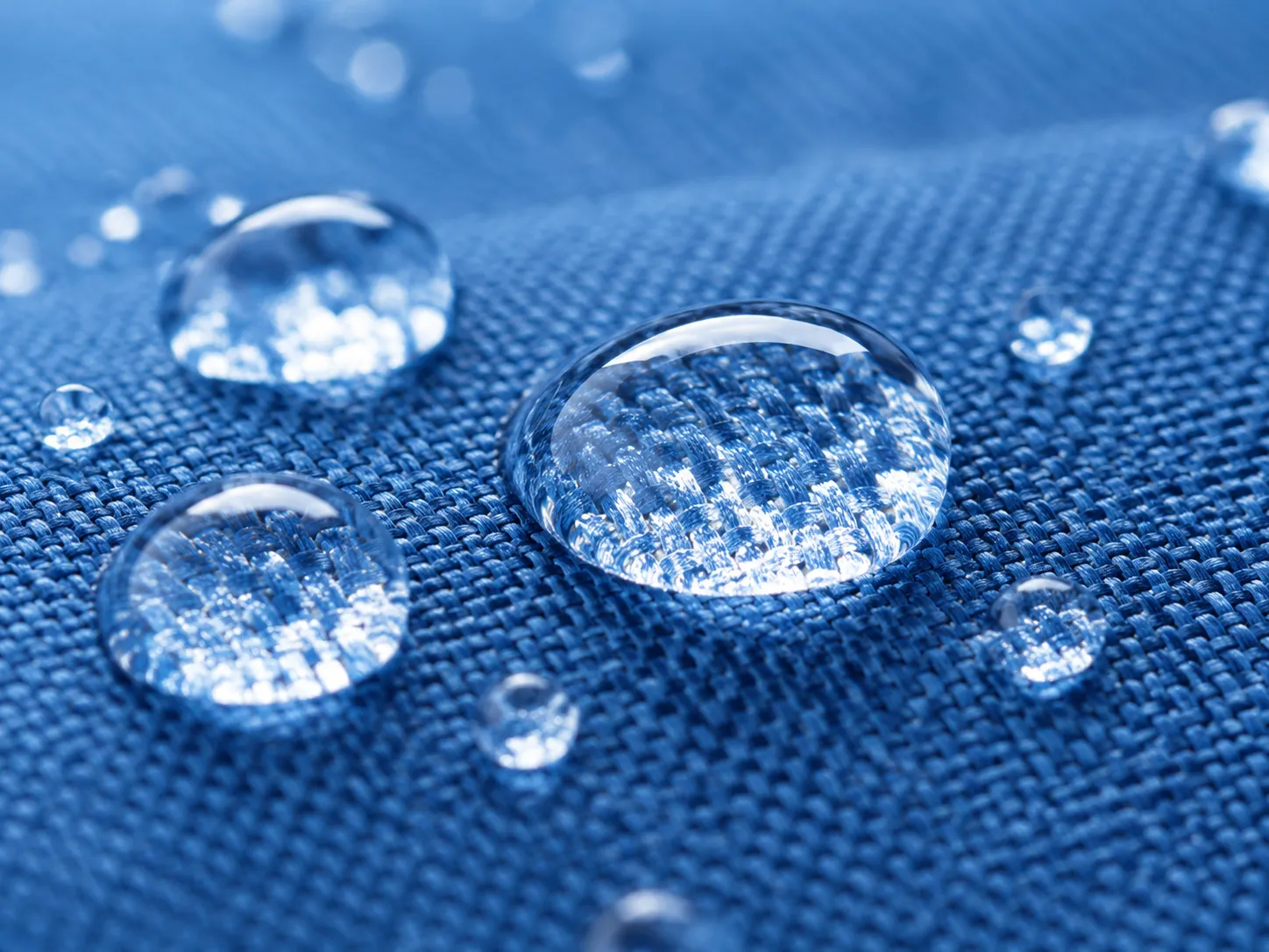撥水加工した生地の表面で水滴が玉になっているイメージ（生成AI画像）